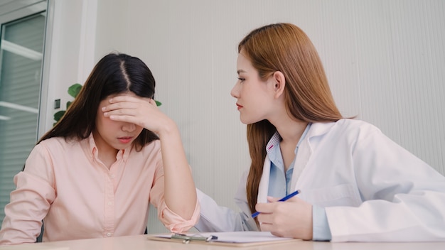 Doctor talking to unhappy teenage patient in exam room. 
