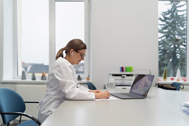 Doctor teleconsulting patient on laptop