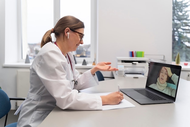 Free photo doctor teleconsulting patient on laptop