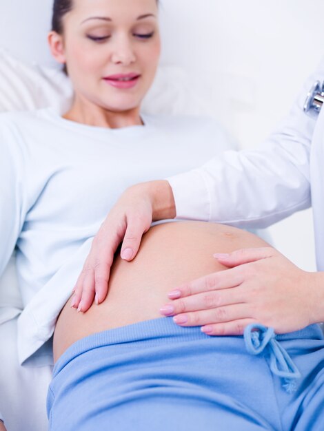 Doctor touches the belly of a pregnant woman