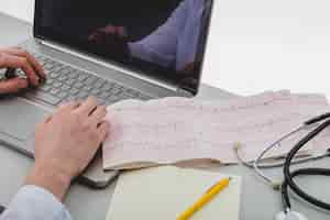 Free photo doctor typing a laptop