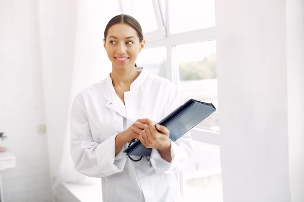 Foto gratuita medico in un'uniforme che sta sul bianco