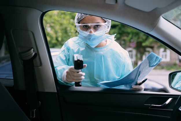 Doctor uses infrared thermometer gun to check body temperature