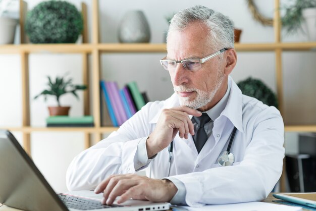 Doctor using laptop and thinking