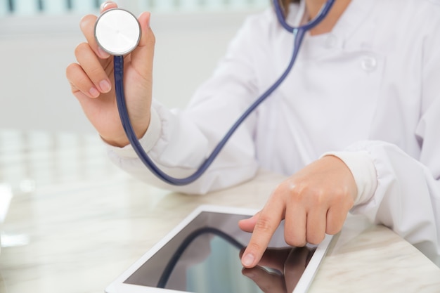 Doctor using a tablet and a stethoscope