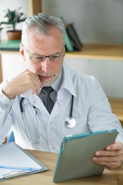 Doctor using tablet and thinking