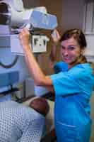 Бесплатное фото Врач с помощью рентгеновского аппарата для изучения пациента