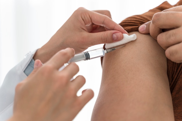 Doctor vaccinating a man close-up