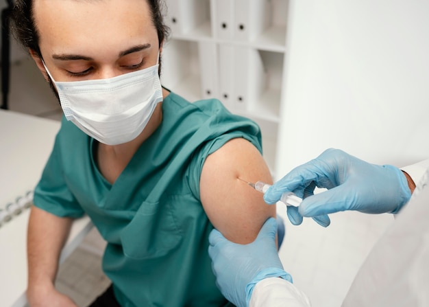 Foto gratuita medico che vaccina un paziente in clinica