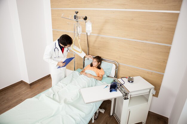 病室で患者の女の子を訪問する医師