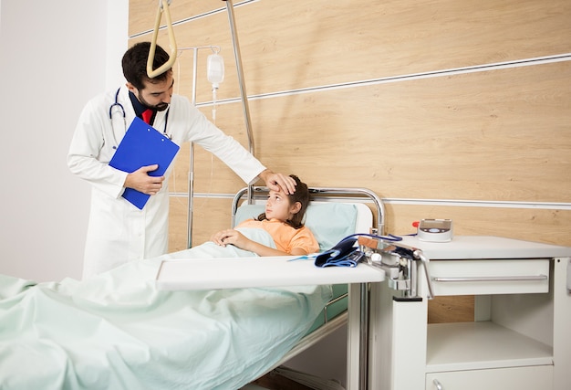 Il dottore visita la ragazza paziente nella stanza d'ospedale