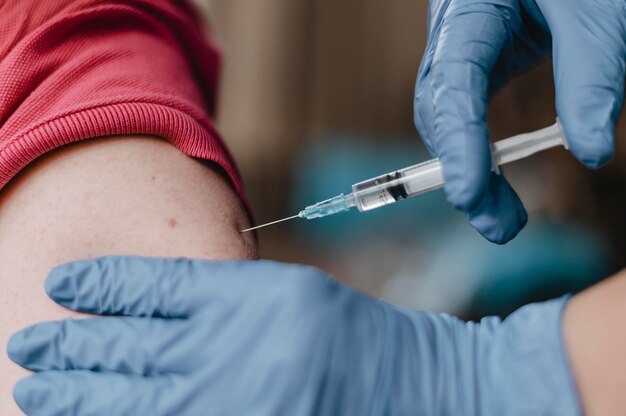 Доктор в перчатках и делает ребенку вакцину