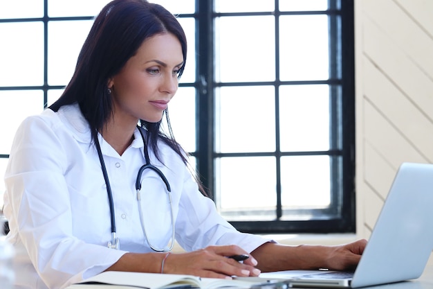 Free photo doctor wearing white robe and stethoscope