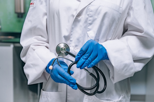 Doctor in a white robe holding a phonendoscope