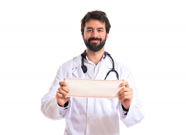 Doctor with bandage over white background