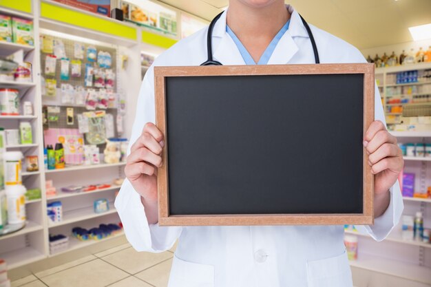 Doctor with a blackboard in a pharmacy