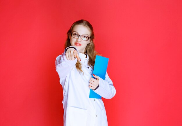 Doctor with a blue folder greeting her patient.