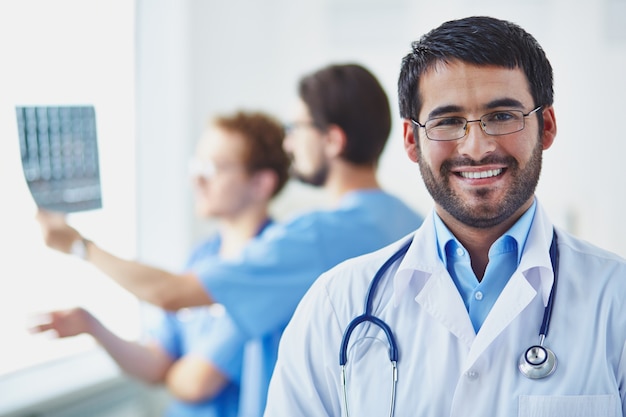 Free photo doctor with co-workers analyzing an x-ray