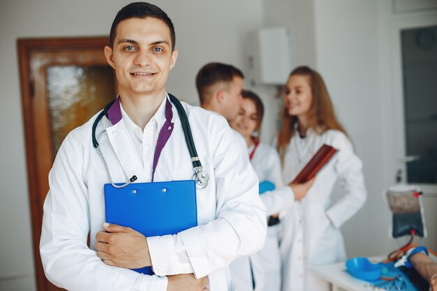 Doctor with a folder in his hands looks at the camera