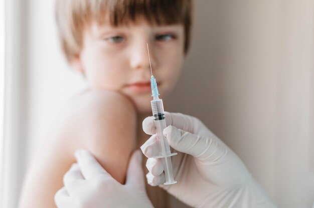 Doctor with gloves getting a vaccine for kid