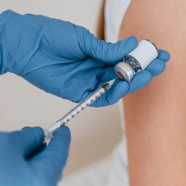 Doctor with gloves preparing syringe with vaccine