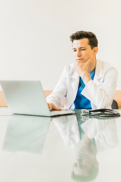 Free photo doctor with laptop at desk