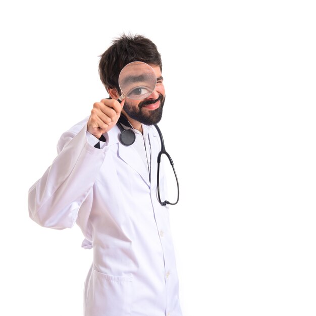 Doctor with magnifying glass over white background