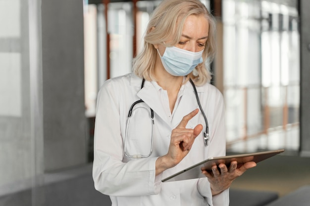 Doctor with medical mask checking her notes