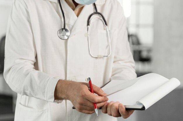 Doctor with medical mask checking his notes