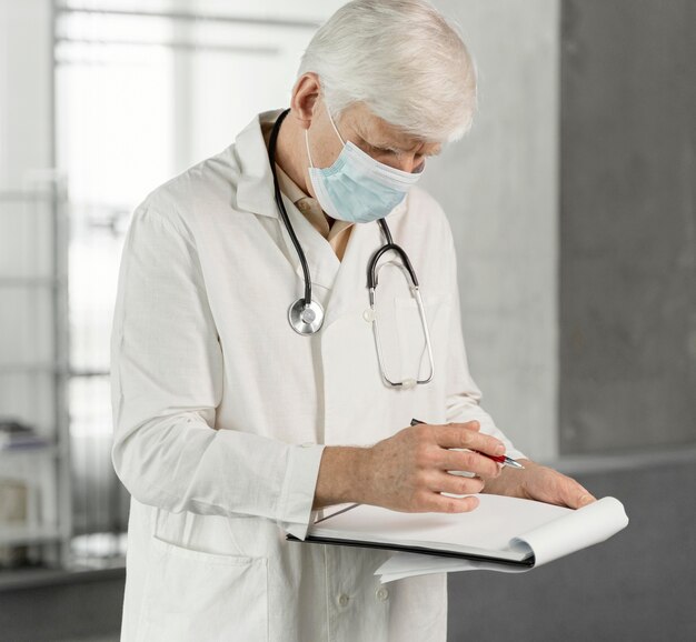 Doctor with medical mask checking his notes