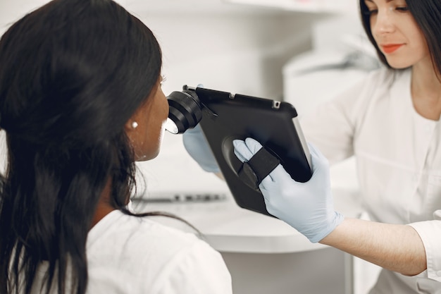 Free photo doctor with tool. girl checks skin. treatment of facial problems.