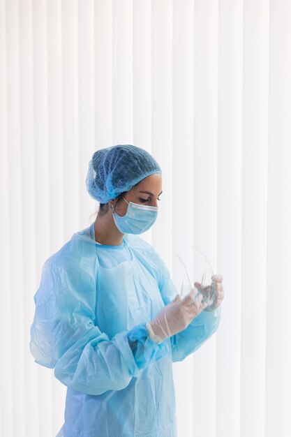 Doctor woman holding protective goggles