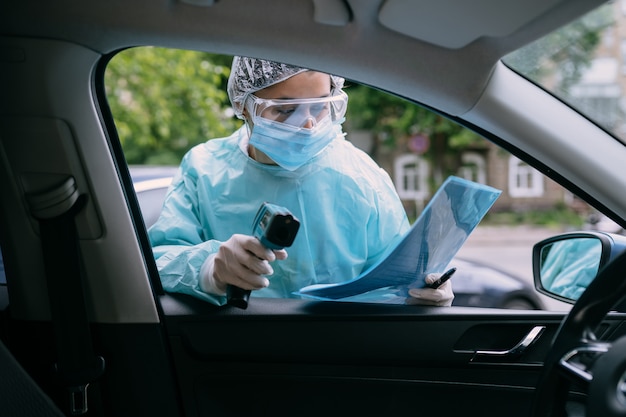 Doctor woman use infrared thermometer gun to check body temperature