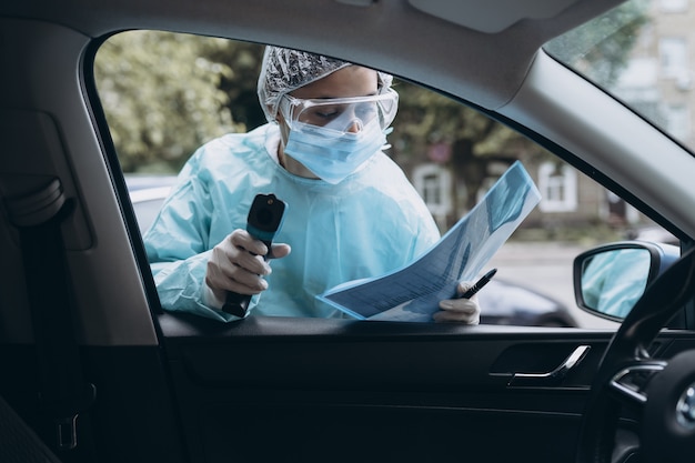 Free photo doctor woman uses infrared thermometer gun to check body temperature