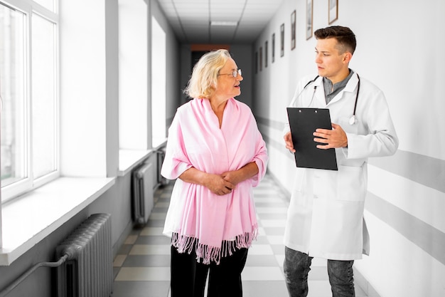 Doctor and woman walking on hospital hall