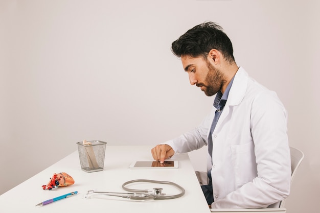 Free photo doctor working with tablet in the office