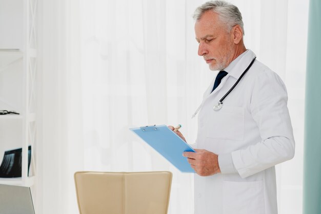 Doctor writing on clipboard