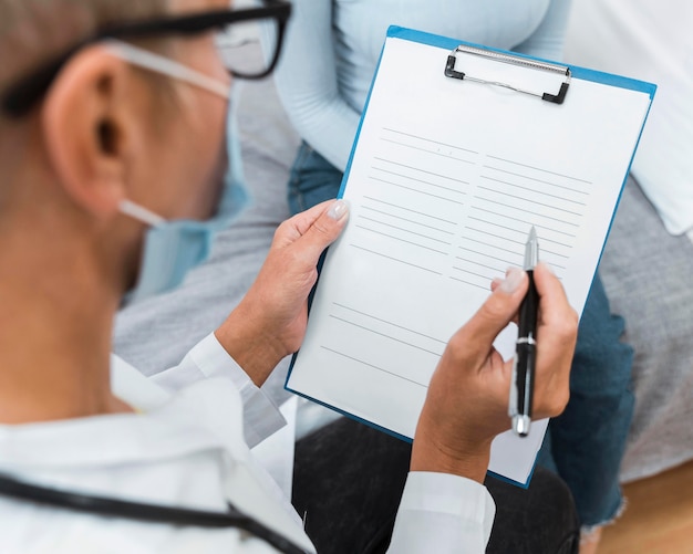 Doctor writing notes on a clipboard