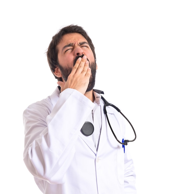 Doctor yawning over isolated white background