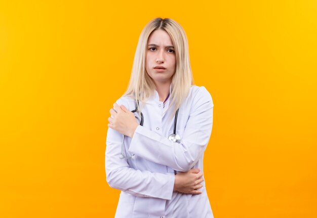  doctor young girl wearing stethoscope in medical gown put her hand on shoulder on isolated yellow wall