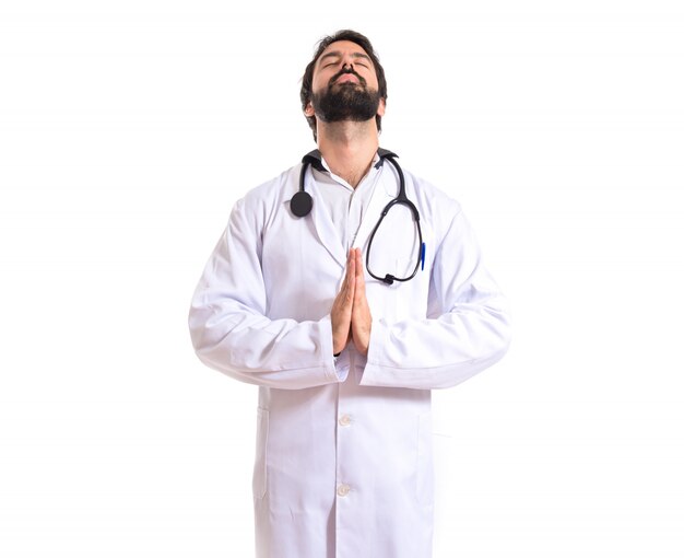 Doctor in zen position over white background
