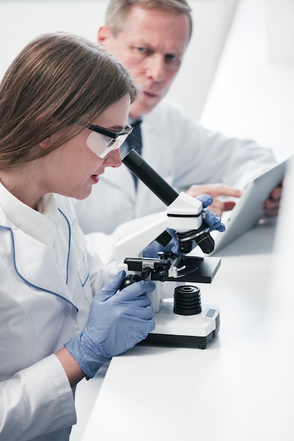 Doctors analyzing with a microscope