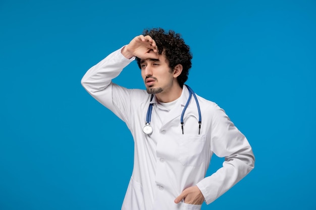 Doctors day curly brunette cute guy in lab coat thinking and tired