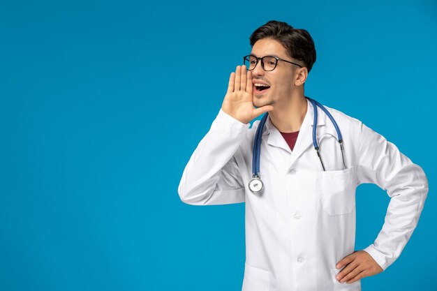 Doctors day cute young handsome man in lab coat and glasses screaming and calling for help