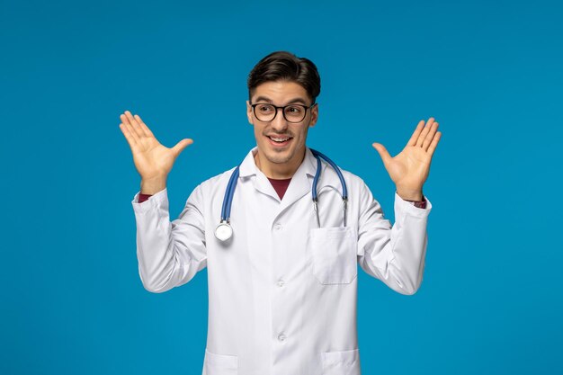 Doctors day handsome brunette cute guy in medical gown waving hands