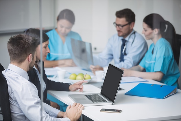 Doctors discussing over laptop in meeting
