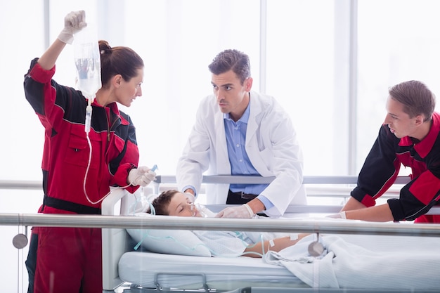 Doctors examining patient in corridor