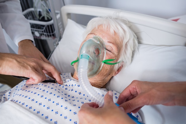 Doctors examining senior patient with stethoscope