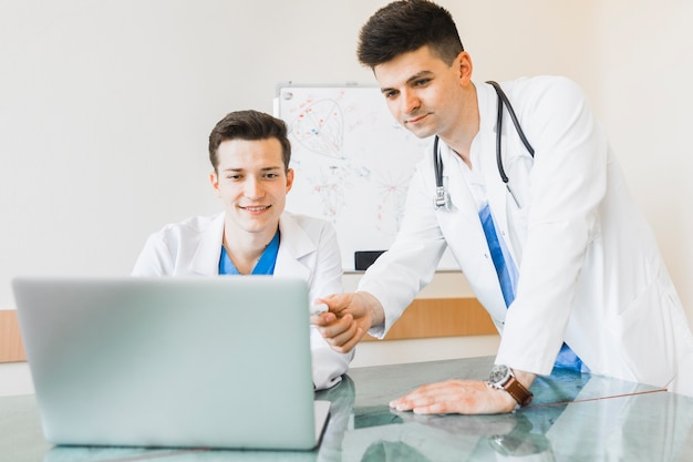 Free photo doctors looking at laptop