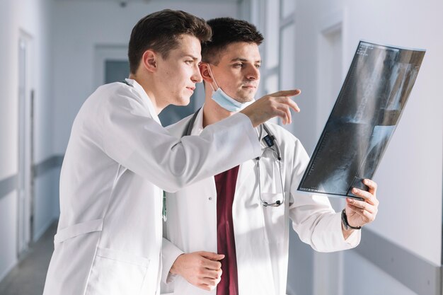 Doctors looking at x-ray in hallway